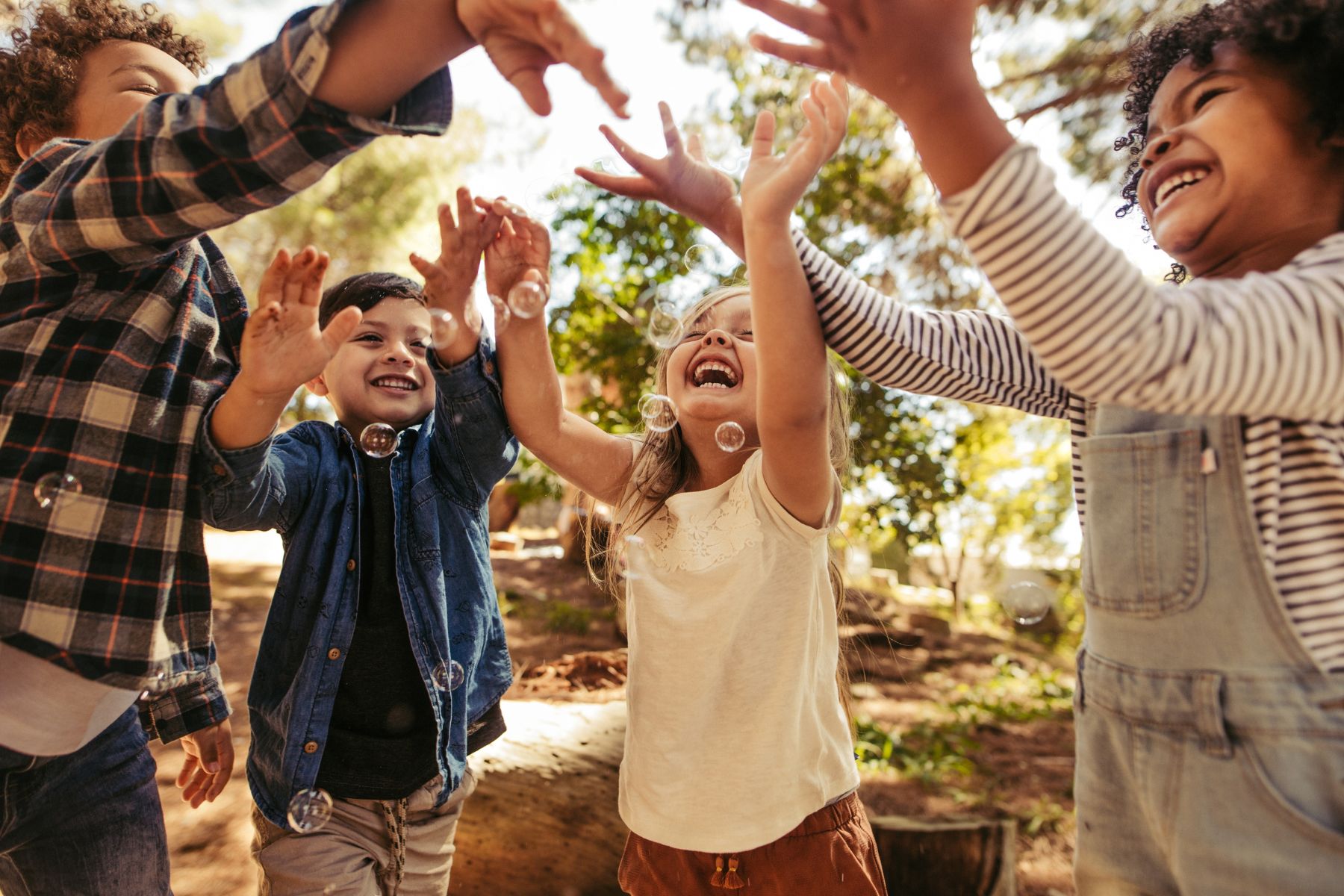 Image of kids happy and blowing bubbles. Canva image.