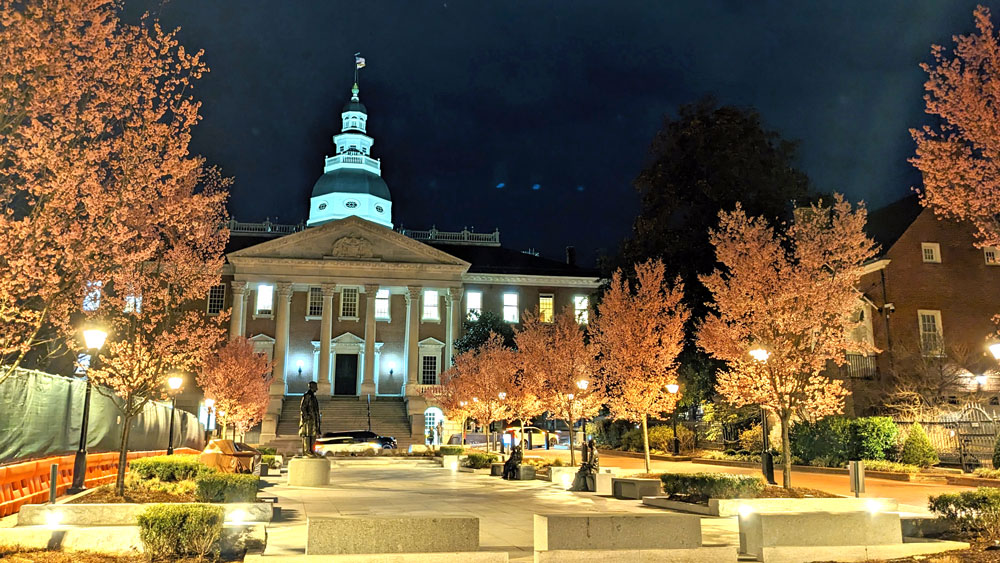 Maryland State House at night with blossoming trees and construction