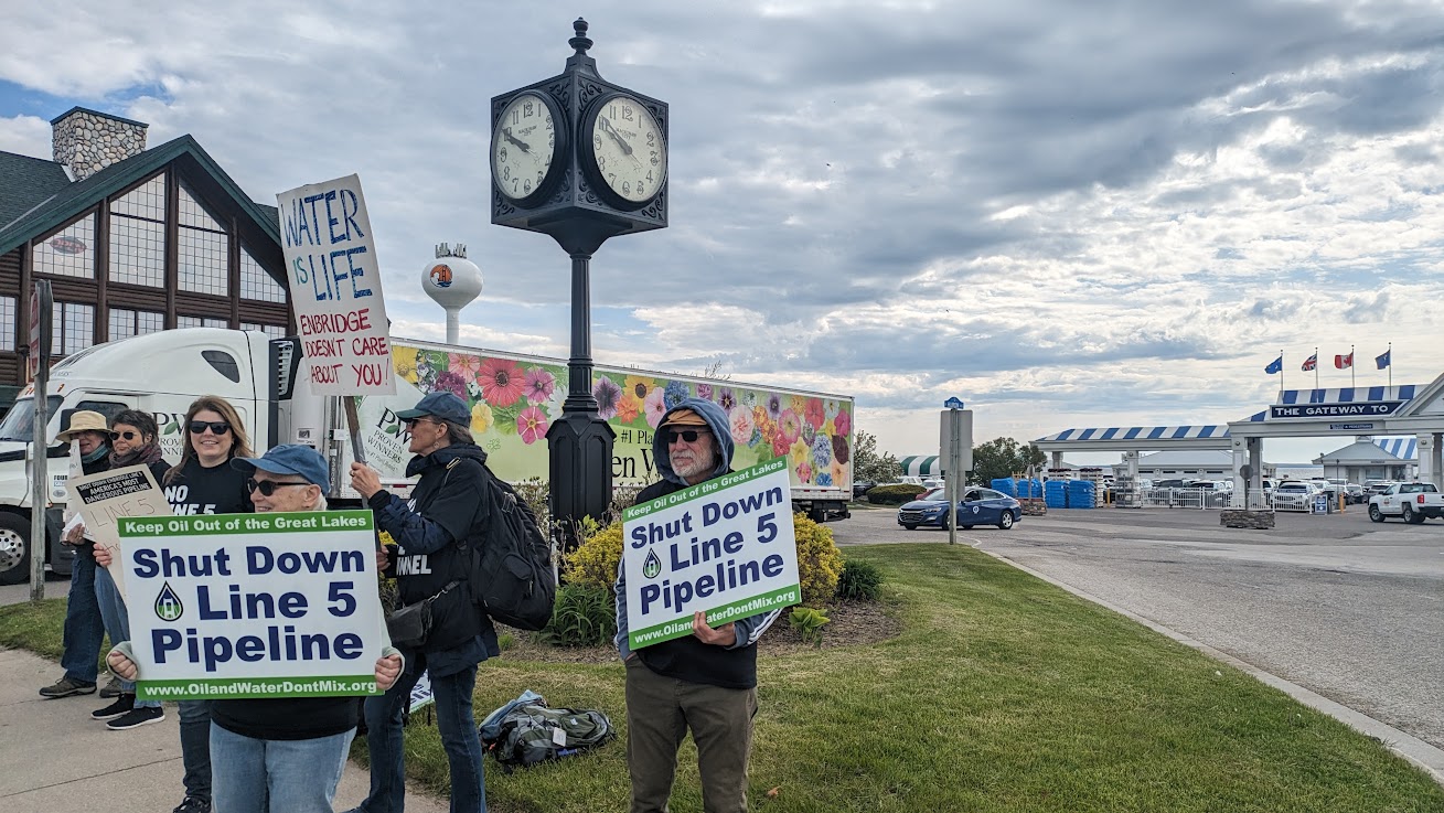 Protestors in Mackinaw City holding "Shut Down Line 5 Pipeline" signs