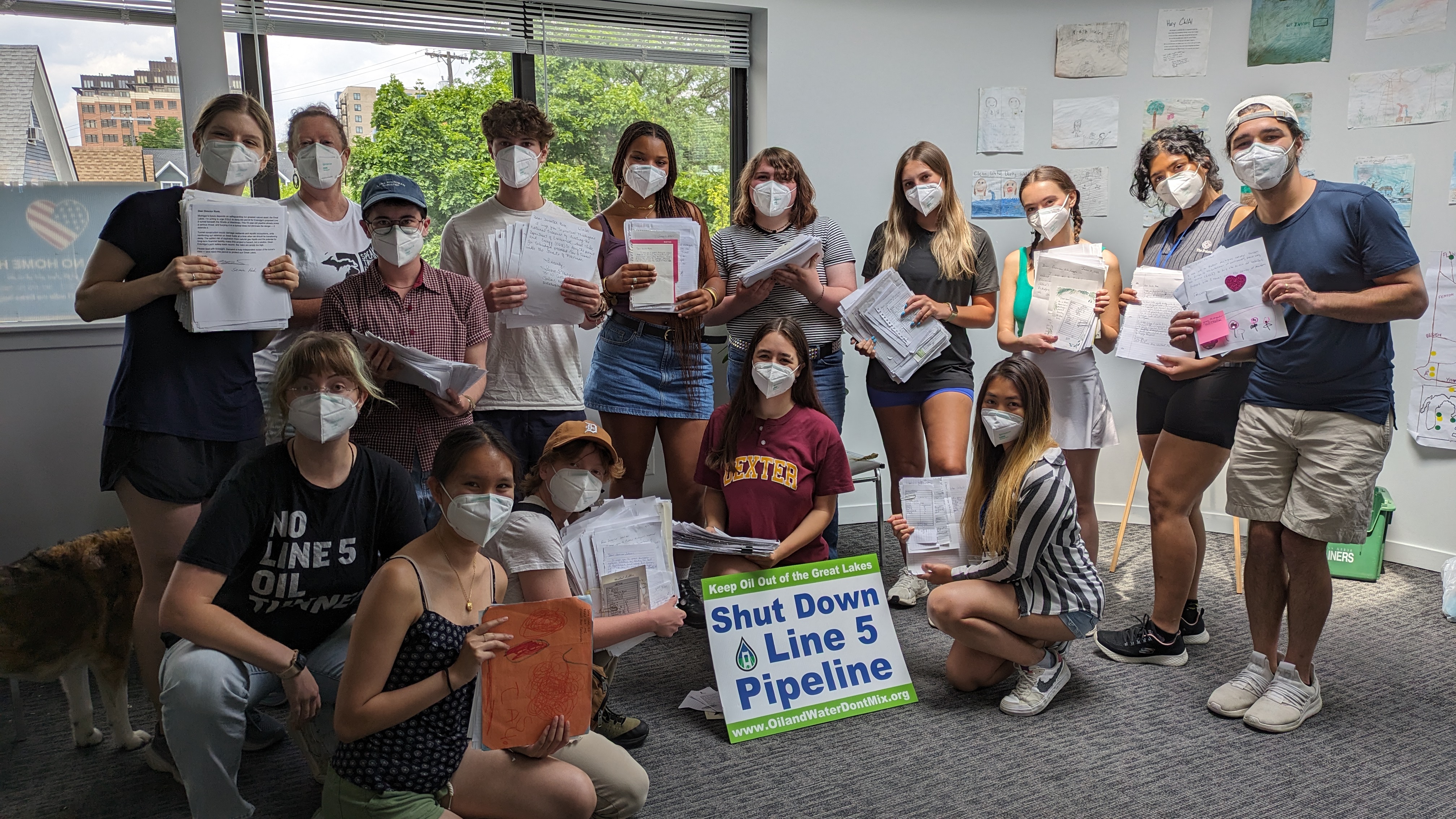Clean Water Action staff posing with letters against the Line 5 pipeline