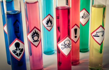 Test tubes of chemicals with hazard labels