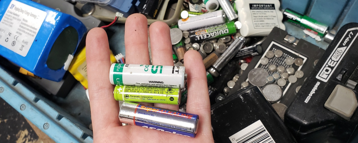 Variety of old batteries in a waste bin