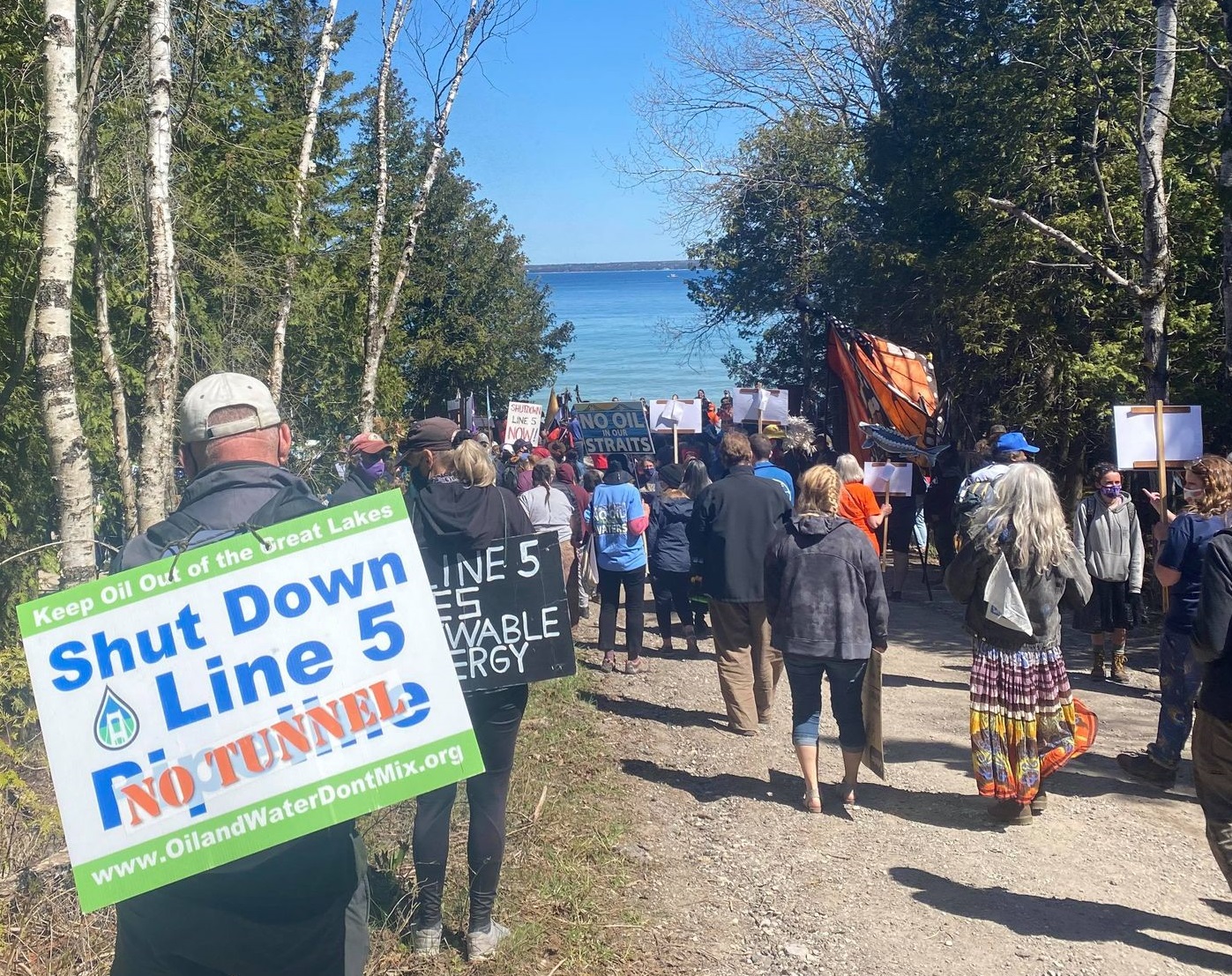 Crowd marching on Lake Michigan with Shut Down Line 5 Signs