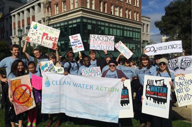 Gathering for demonstration against frackign in California including Clean Water Action banner and signs "Get The Frack Out Of Here"