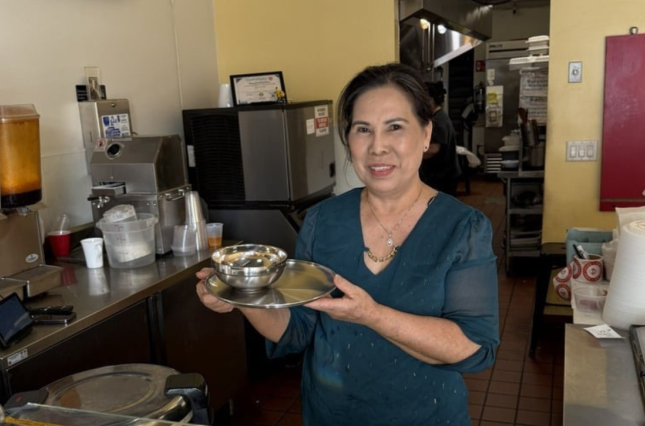 Owner of Thai Chili showing off new stainless steel plates and bowls