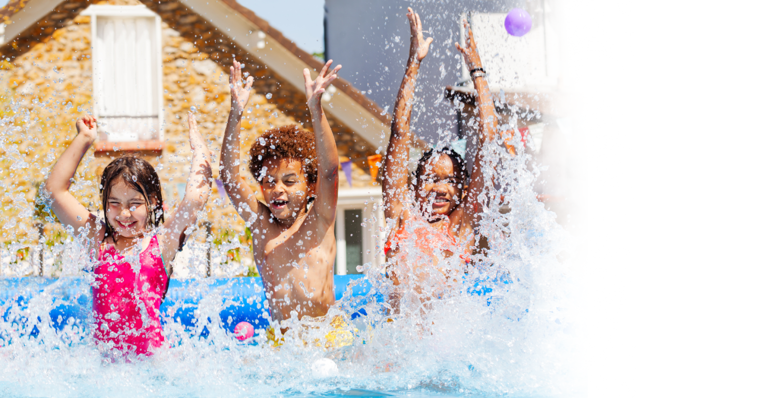 Three kids jumping in a backyard pool.
