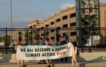 People holding banner in Detorit: "We all deserve a future! Climate action now! [Credit Jennifer Schlicht]"
