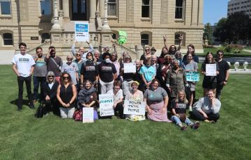 Large group of MMOP supporters posing on the Michigan Capitol Lawn across the street from the State Board Of Canvassers meeting.