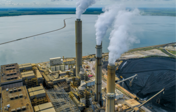 coal plant on a body of water - canva image.