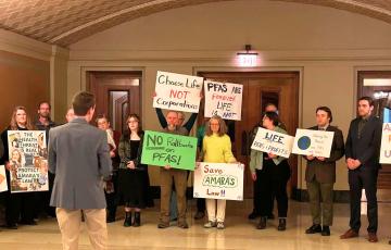 Rally in the MN State Capitol building with signs like "Save Amara's Law" and "No Rollbacks on PFAS!"