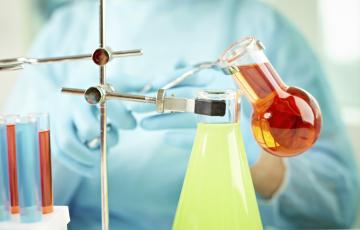 Chemicals being mixed in beakers. Photo credit: mediaphotos / Shutterstock