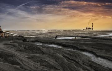 Acres of coal ash with a plant in the background