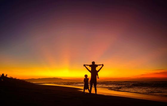 Image of a family on the beach at sunset