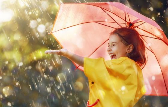 Photo of girl laughing under an umbrella in the rain