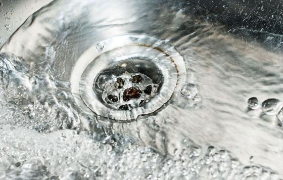 Water flowing into a drain. Photo credit: Jitinatt Jufask / Shutterstock